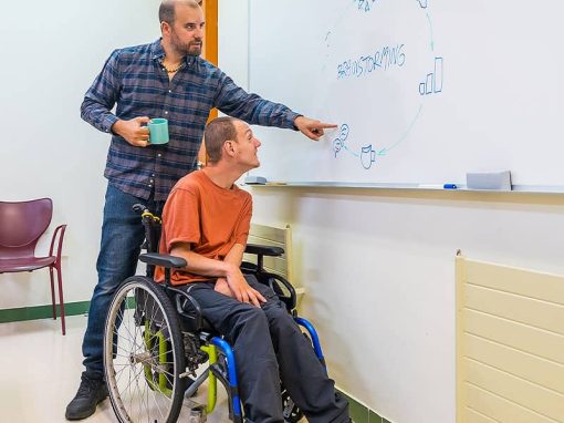 Persönliche Assistenz in Düsseldorf: PAT gGmbH. Assistent hilft seinem Klienten in der Schule an der Tafel.